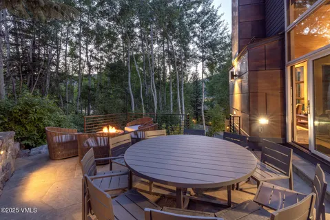 a view of a patio with table and chairs with wooden floor and fence