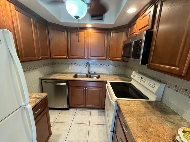 a kitchen with granite countertop a sink and a stove top oven