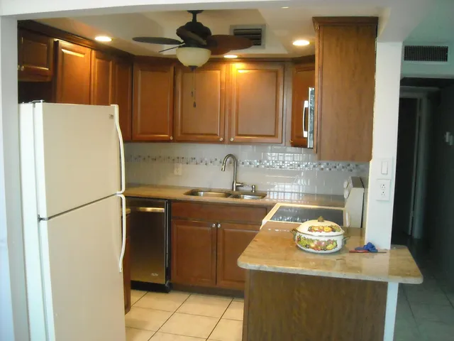 a kitchen with a sink a refrigerator and a stove top oven