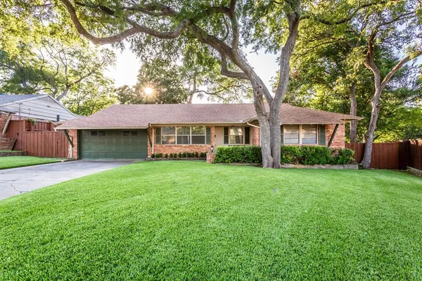 a front view of a house with yard and green space