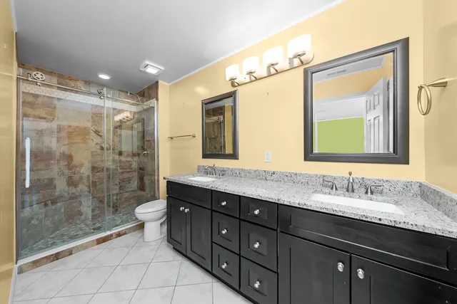 a bathroom with a granite countertop sink mirror and a shower