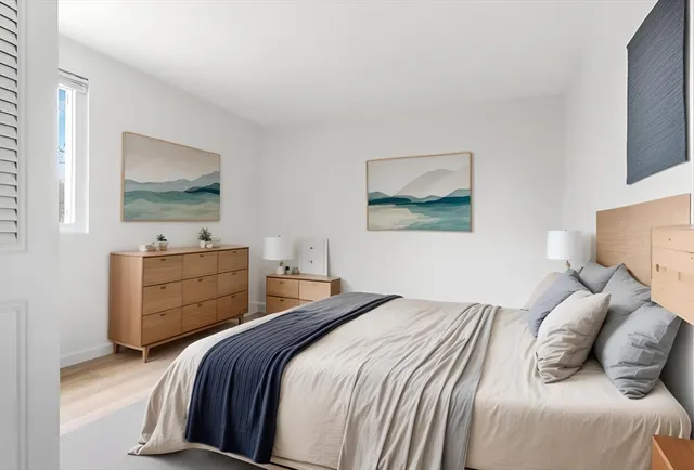 a bedroom with a bed and wooden floor