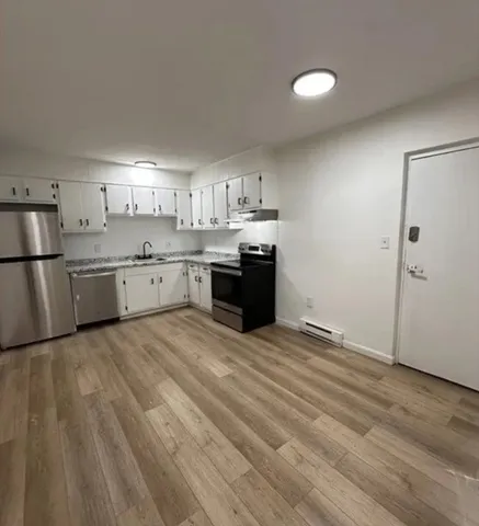 a large kitchen with cabinets and stainless steel appliances