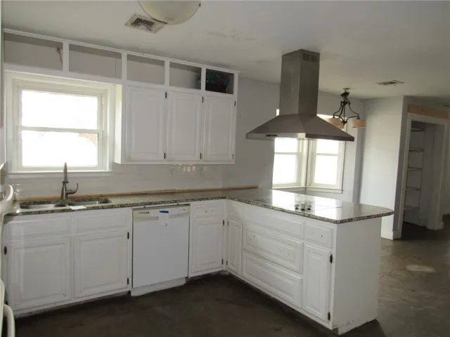 a kitchen with granite countertop white cabinets and a sink