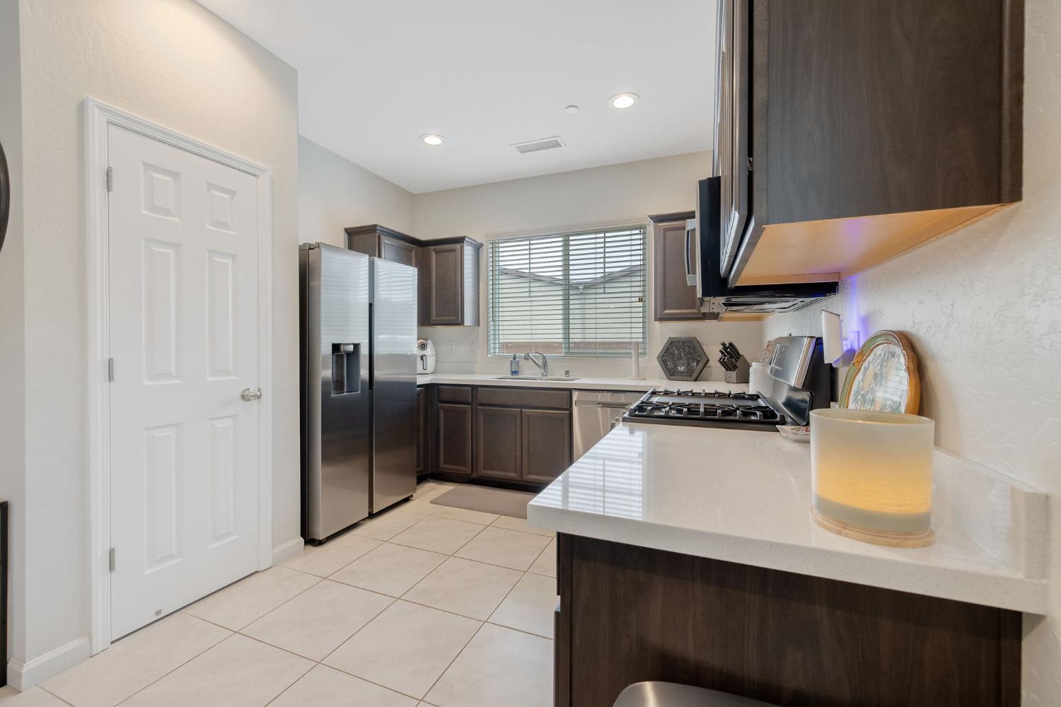 535 Sandtrap Lane Lemoore, CA 93245 - Photo 11 of 36 a kitchen with a refrigerator a sink a stove and cabinets