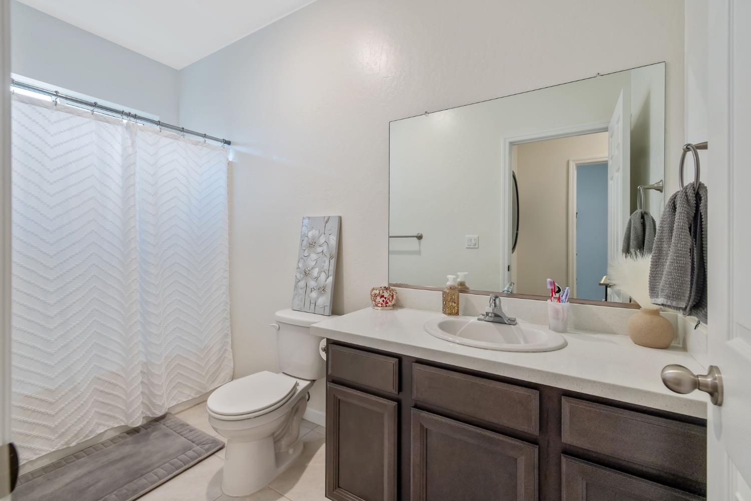 535 Sandtrap Lane Lemoore, CA 93245 - Photo 21 of 36 a bathroom with a sink vanity mirror and toilet