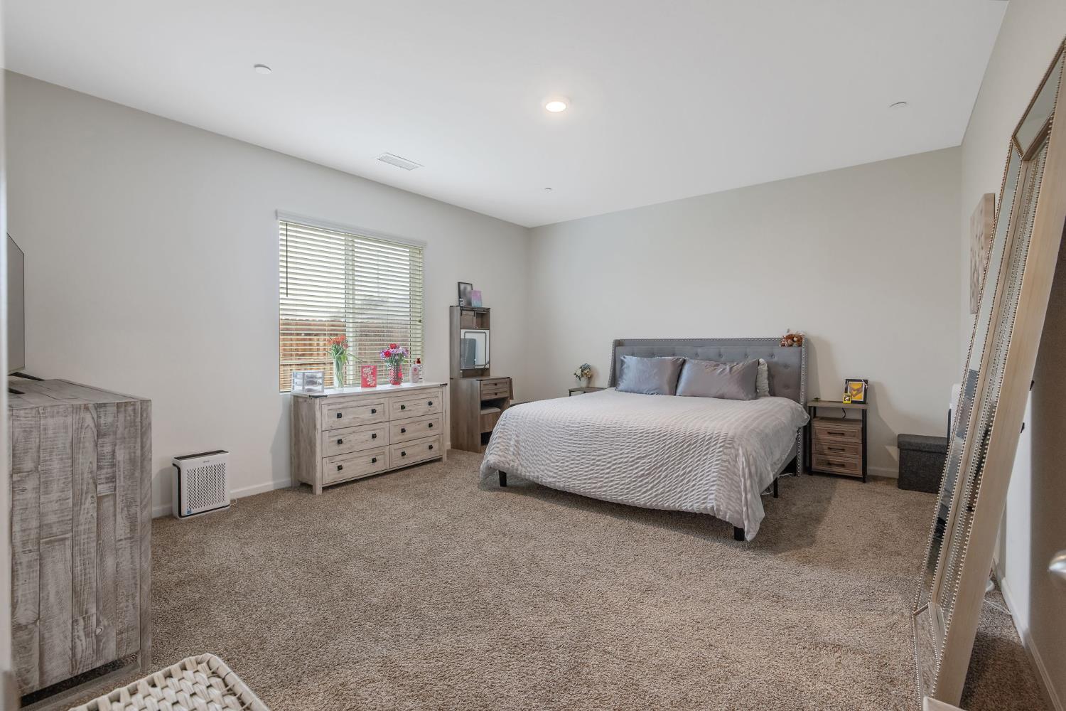 535 Sandtrap Lane Lemoore, CA 93245 - Photo 24 of 36 a spacious bedroom with a bed and a couch