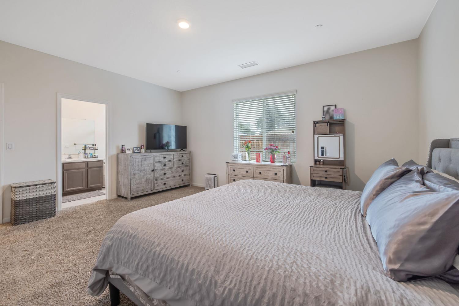 535 Sandtrap Lane Lemoore, CA 93245 - Photo 25 of 36 a spacious bedroom with a bed and a flat screen tv