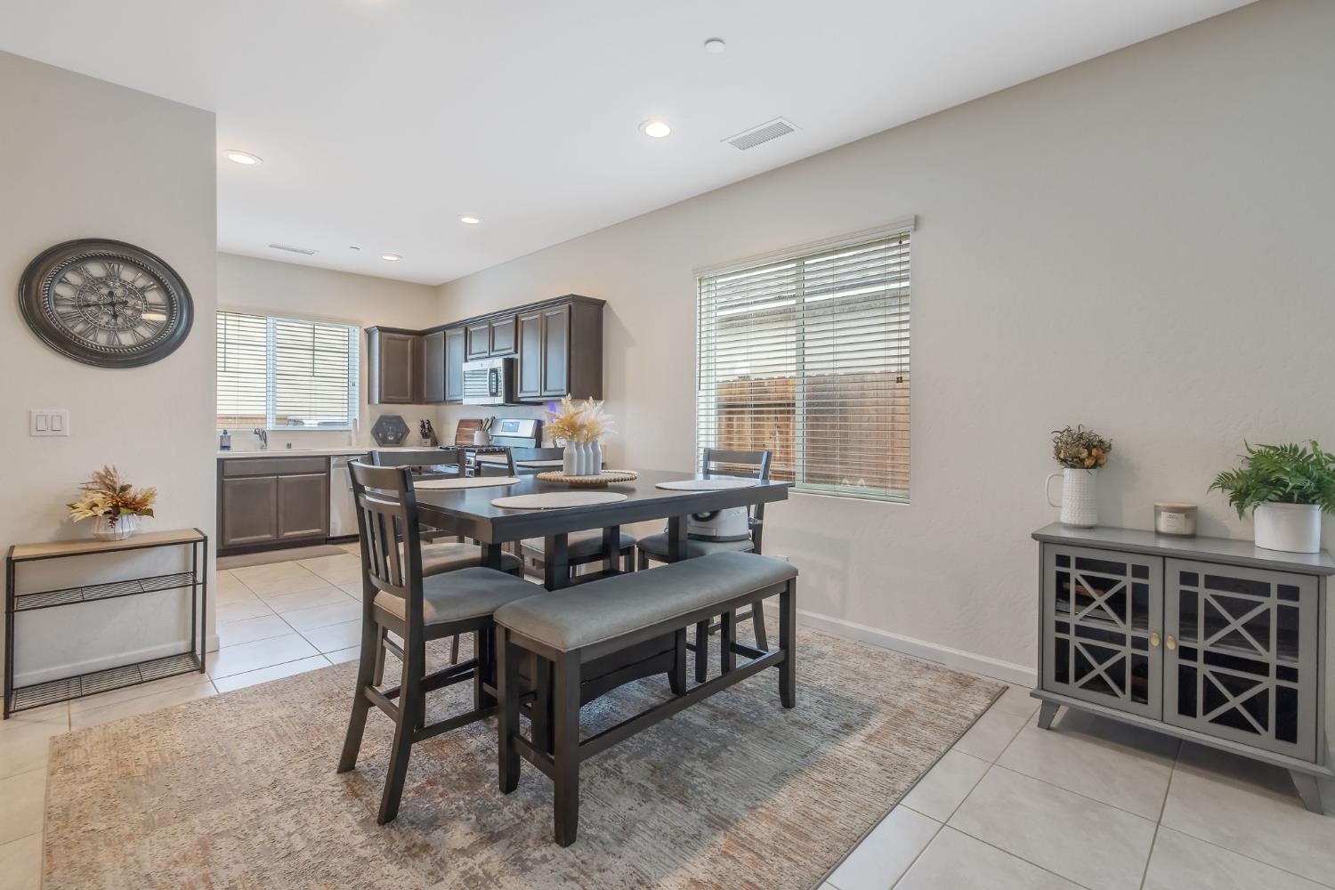 535 Sandtrap Lane Lemoore, CA 93245 - Photo 7 of 36 a kitchen with stainless steel appliances a table and chairs in it