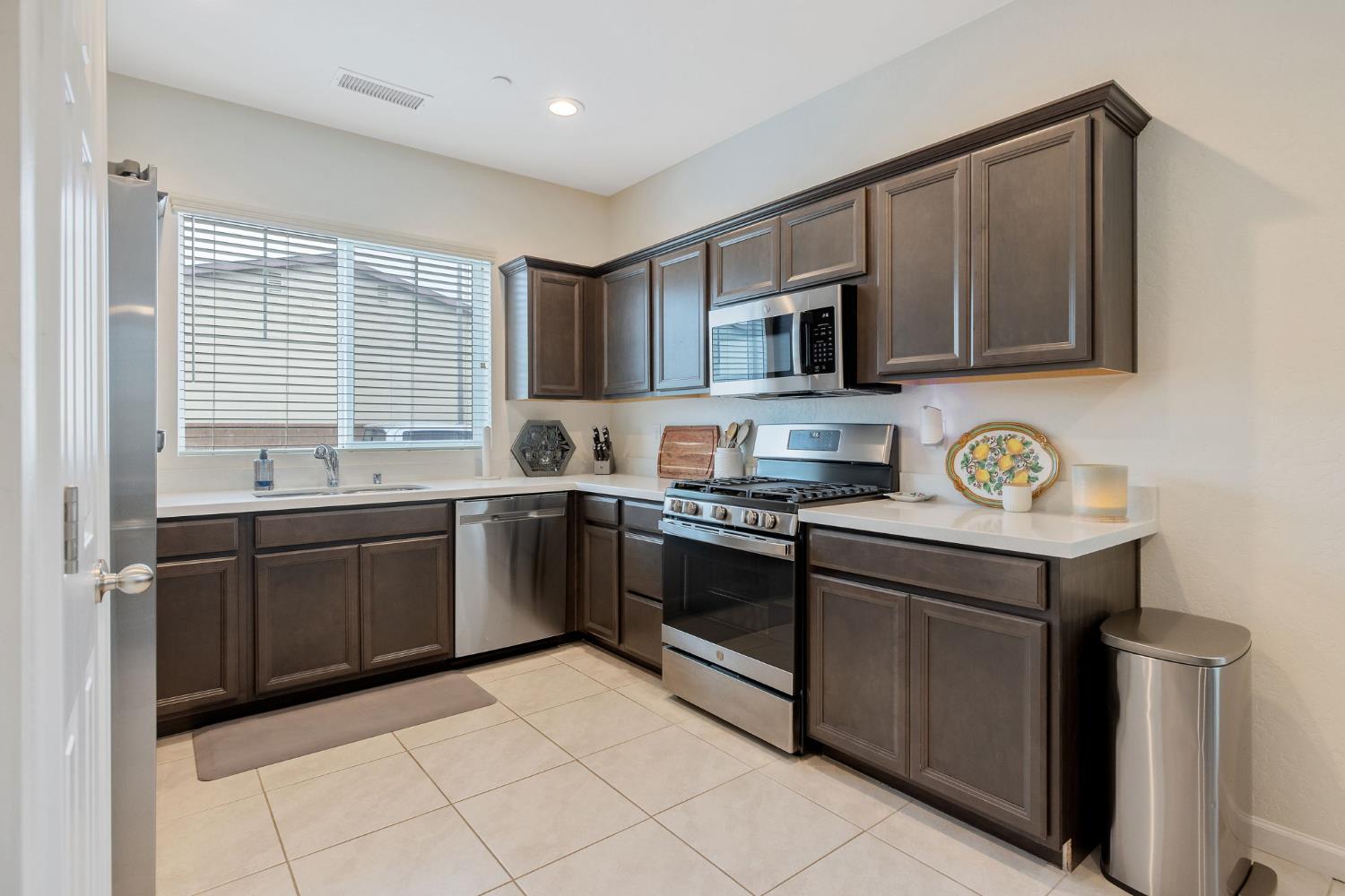 535 Sandtrap Lane Lemoore, CA 93245 - Photo 9 of 36 a kitchen with stainless steel appliances granite countertop a stove sink and cabinets
