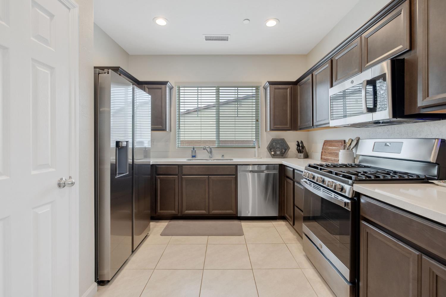 535 Sandtrap Lane Lemoore, CA 93245 - Photo 10 of 36 a kitchen with stainless steel appliances granite countertop a stove a sink and a refrigerator