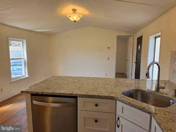 a kitchen with granite countertop a sink and cabinets