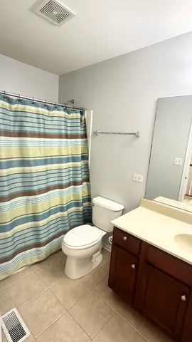 a bathroom with a sink a toilet a mirror and shower curtain