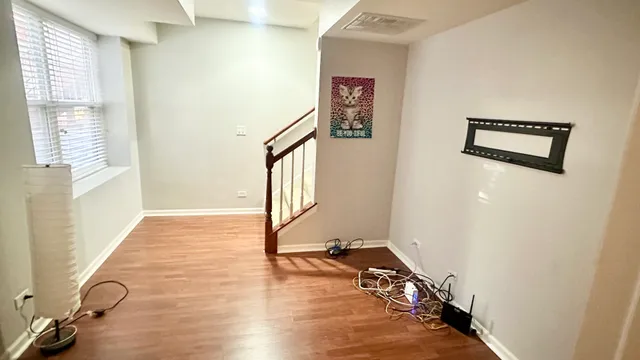 a view of a hallway with wooden floor and stairs