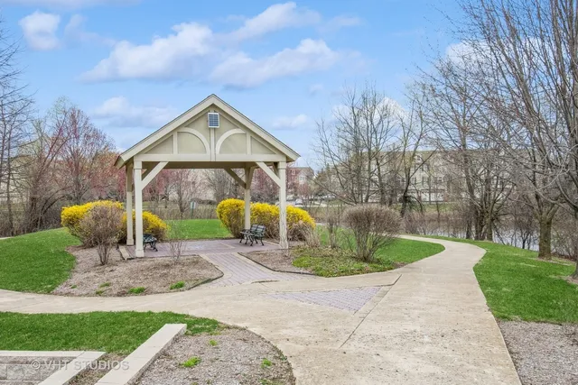 a view of a house with garden and a pond
