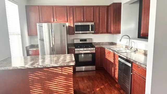 a kitchen with stainless steel appliances granite countertop a stove a sink and a microwave