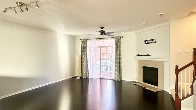 a view of a livingroom with wooden floor and a ceiling fan