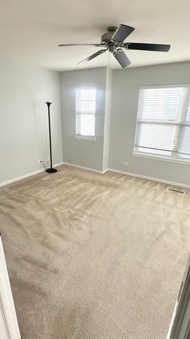 an empty room with windows and cabinet
