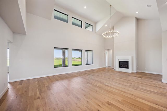 an empty room with windows and fireplace