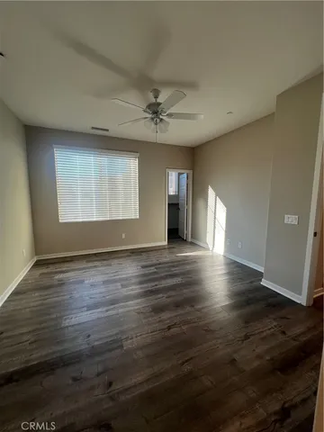 a view of storage and utility room with wooden floor and window