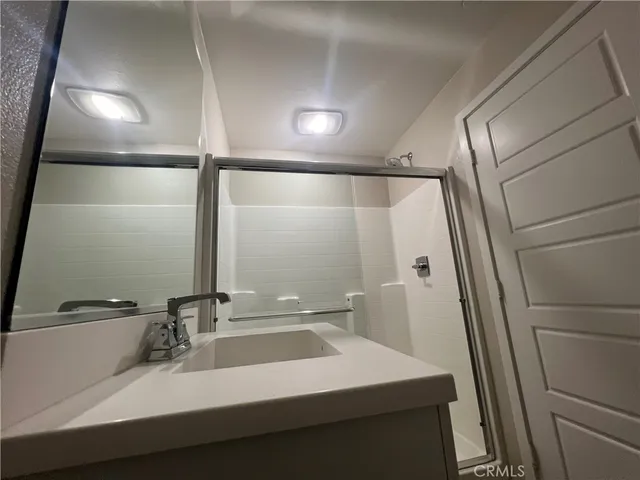 a bathroom with a sink shower and a mirror