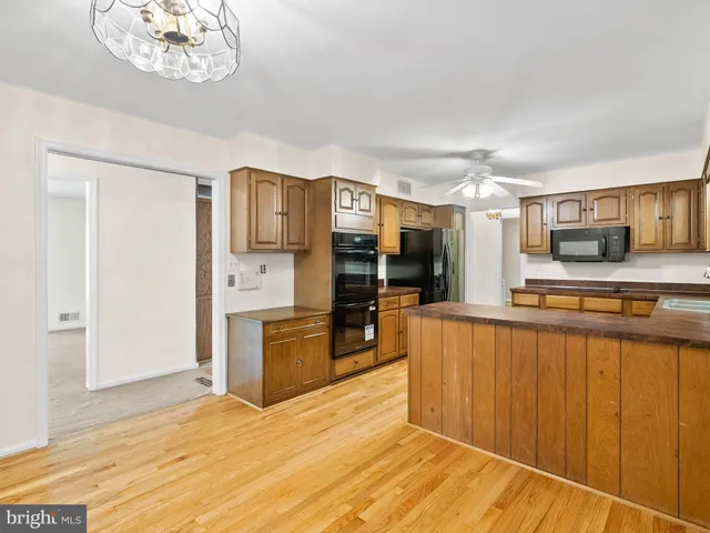 a kitchen with a refrigerator and a stove top oven
