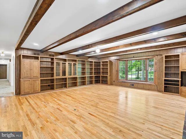 a view of empty room with wooden floor and fireplace