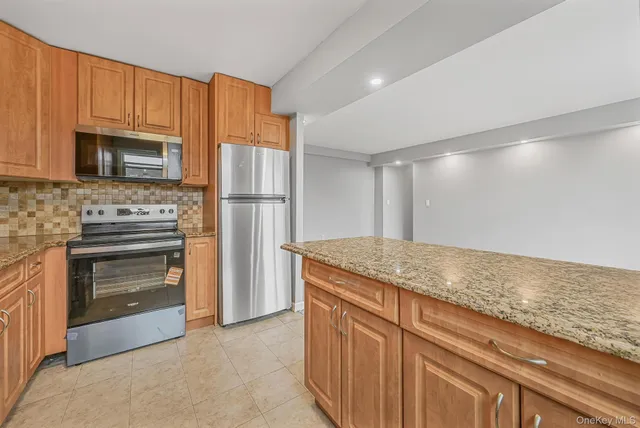 a kitchen with granite countertop cabinets stainless steel appliances and a counter space