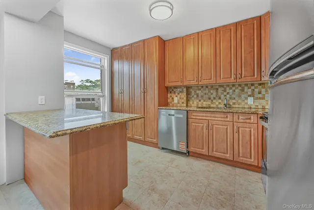 a kitchen with stainless steel appliances granite countertop wooden cabinets a sink and a stove