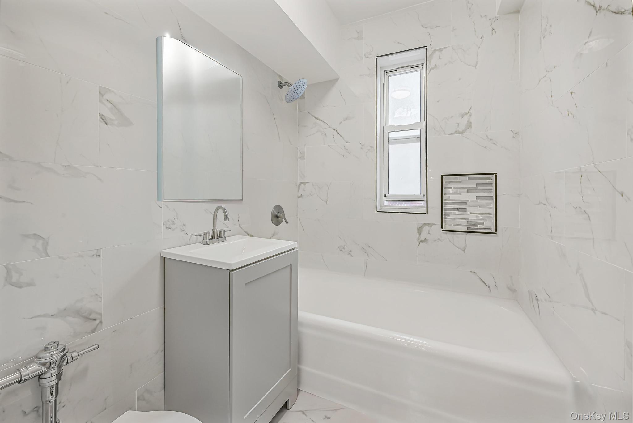 160 72nd Street, Unit 758 Brooklyn, NY 11209 - Photo 8 of 10 a white bath tub sitting next to a white sink