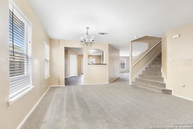 a view of a big room with windows and chandelier