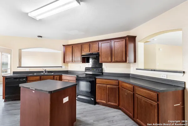 a kitchen with stainless steel appliances granite countertop a stove a sink dishwasher and a microwave oven with cabinets