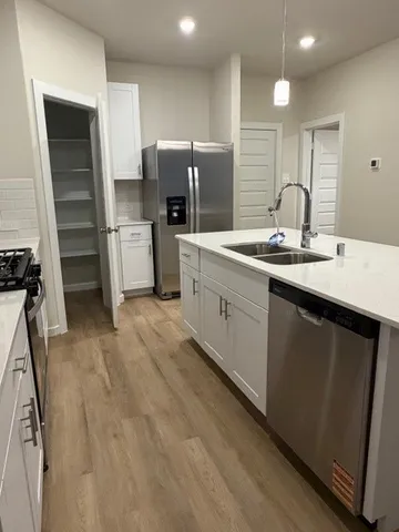 a kitchen with a sink refrigerator and cabinets