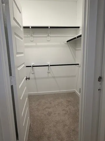a view of walk in closet with empty racks
