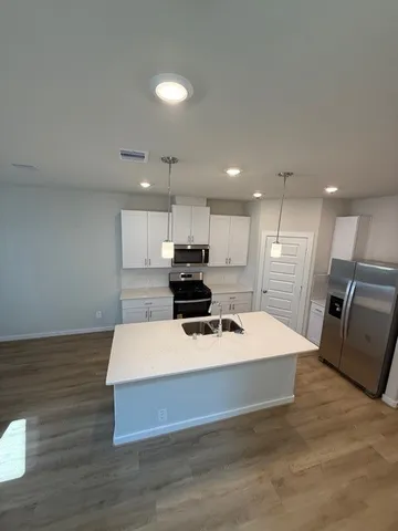 a large kitchen with stainless steel appliances kitchen island a sink dishwasher a refrigerator and a stove