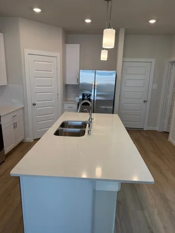 a kitchen with kitchen island a sink stainless steel appliances and cabinets