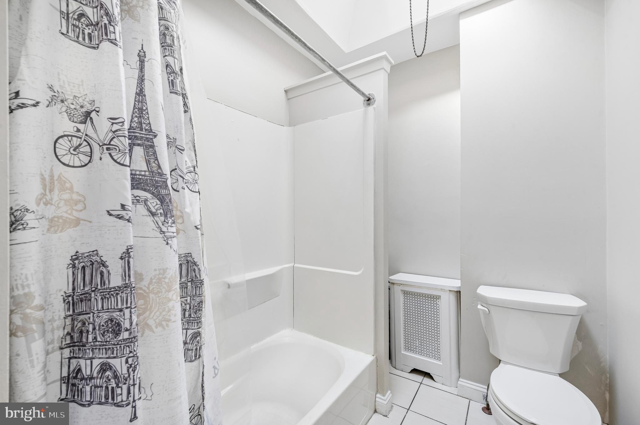 5428 Whitby Avenue Philadelphia, PA 19143 - Photo 13 of 15 a white toilet sitting next to a bath tub