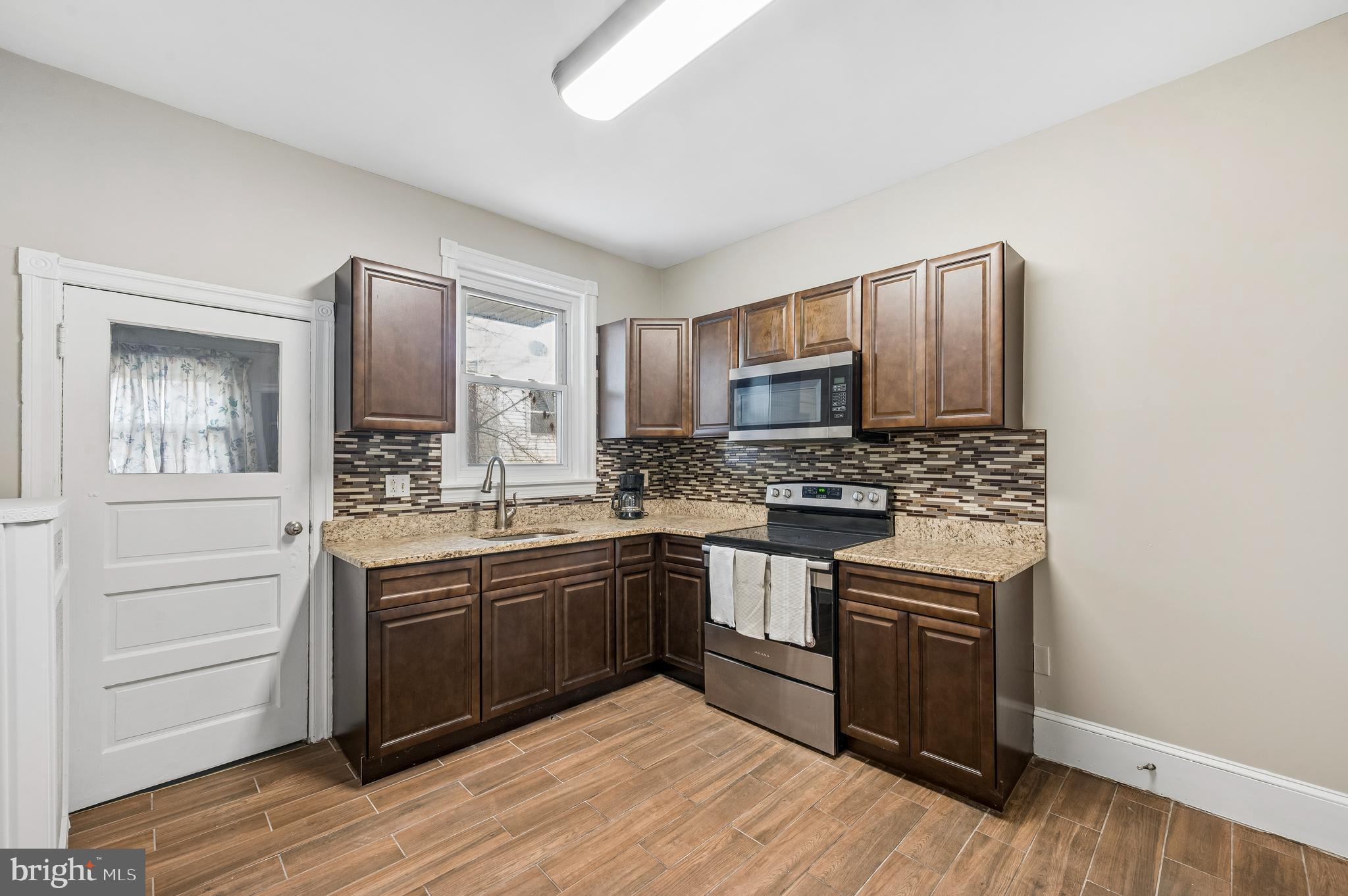 5428 Whitby Avenue Philadelphia, PA 19143 - Photo 9 of 15 a kitchen with stainless steel appliances granite countertop a stove and a sink