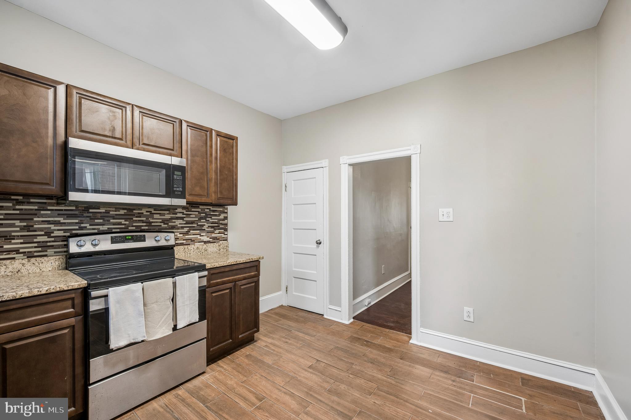 5428 Whitby Avenue Philadelphia, PA 19143 - Photo 10 of 15 a kitchen with stainless steel appliances granite countertop a stove and a microwave