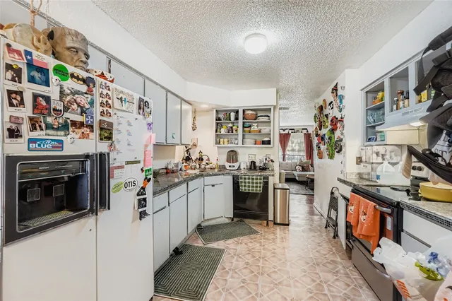 a kitchen with stainless steel appliances granite countertop a stove and a refrigerator