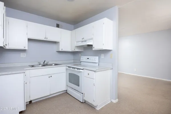 a kitchen with cabinets appliances a sink and a counter top