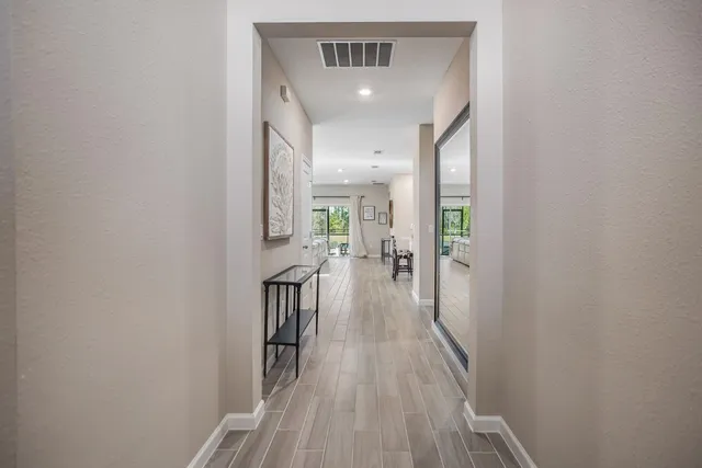 a view of a hallway with wooden floor and staircase