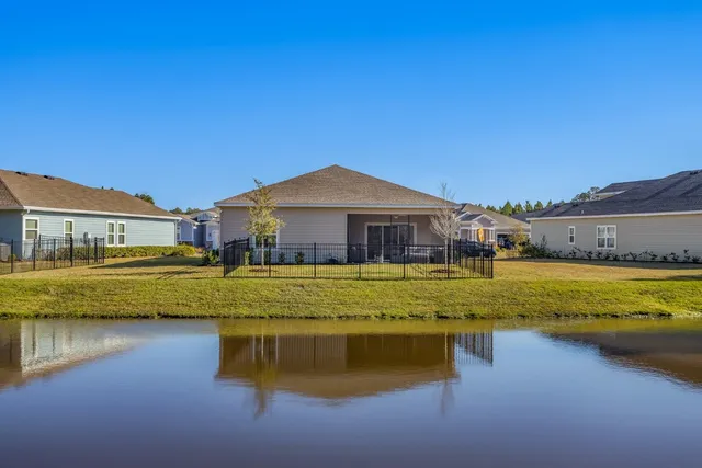 a front view of a house with swimming pool next to a yard
