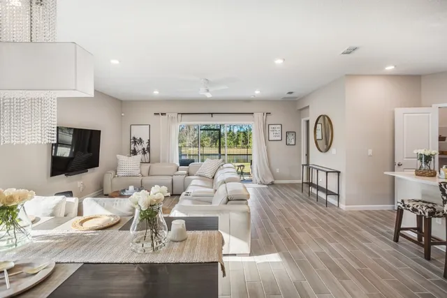 a living room with furniture wooden floor and a flat screen tv
