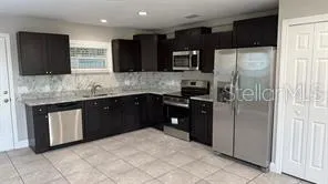 a kitchen with stainless steel appliances granite countertop a refrigerator and a sink