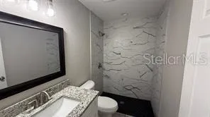 a bathroom with a toilet a sink and shower