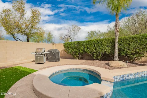 a patio with table and chairs and potted plants