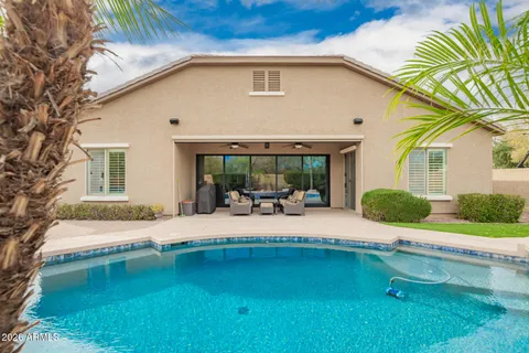 a view of a house with pool and chairs
