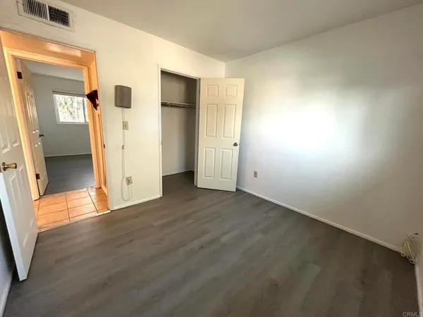 an empty room with wooden floor and a window