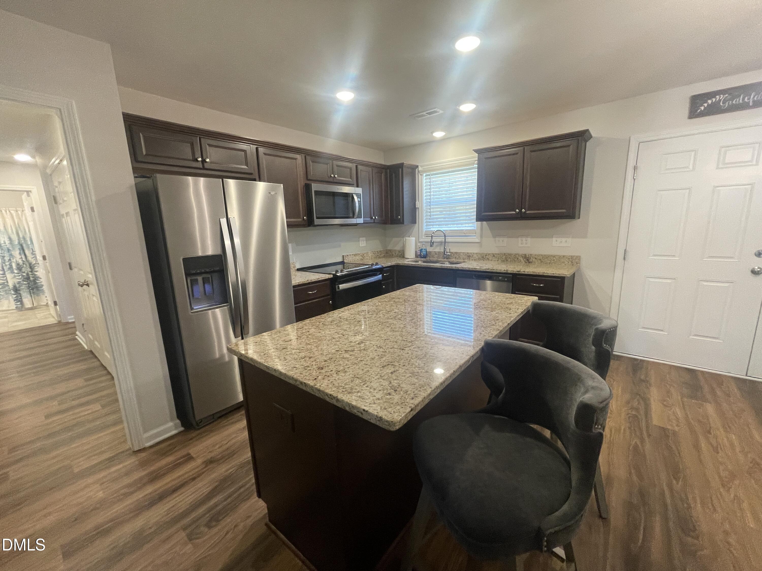 144 Red Hill Church Road Dunn, NC 28334 - Photo 11 of 44 a kitchen with kitchen island a counter top space cabinets and stainless steel appliances